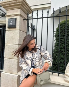 Detail view of a quilted jacket featuring retro floral prints and contrasting edge binding