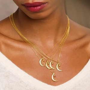 Detail showing gold moon and star layered necklace with colorful birthstones on neck