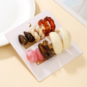 Detailed set of five pairs of colorful acrylic C-shape and drop earrings on white display card