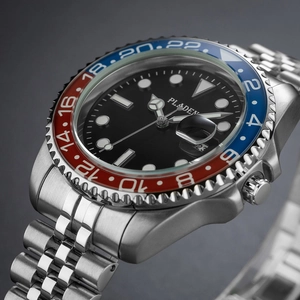 Detail of silver stainless steel watch with red and blue rotating bezel and calendar window