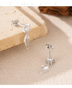 Detail of S925 silver stud earrings with sparkling kite-shaped stones on stone background