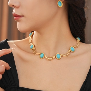 Detail of vintage gold necklace and earring set featuring oval blue turquoise stones