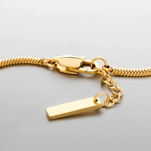 Detail von 18k vergoldetem Karabinerverschluss und Verlängerungskette an quadratischem Armband
