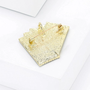 Macro view showing the textured gold metal back and secure pin clasp of the poker brooch