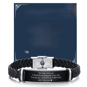 Detail of black braided leather bracelet with engraved stainless steel plaque and card