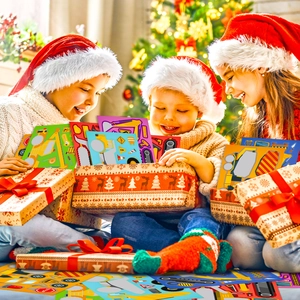 Three children opening a gift box filled with colorful construction vehicle stickers