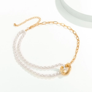 Close-up of golden toggle clasp with asymmetric pearl strands and chunky chain necklace