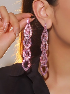 Close-up of luxury long tassel earrings with pink rhinestones on a female model