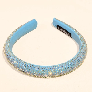 Close-up of light blue rhinestone headband with hand-made label on fabric inner lining