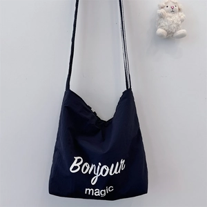 Close-up of black canvas tote bag with Bonjour Magic print and cute sheep charm detail