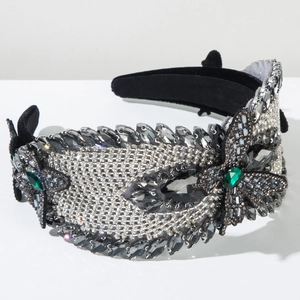 Macro detail of luxury headband featuring emerald green crystals and rhinestone leaf patterns