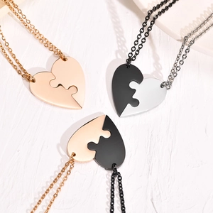Close-up of heart puzzle pendants in gold, black, and silver stainless steel options