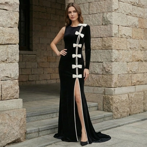 Detail of elegant black velvet evening gown with white bow accents and high leg slit