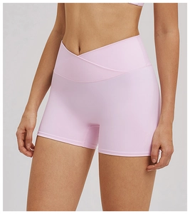 Detail of high-waisted yoga shorts in light pink featuring a unique V-waist crossover design