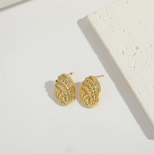 Detail view of gold-plated oval stud earrings with elegant spiral pleated texture