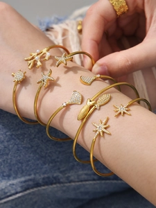 Détails de bracelets superposés dorés 18 carats avec motif marin et zircons