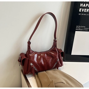 Detail view of burgundy vintage faux leather bag featuring side pockets and zippers