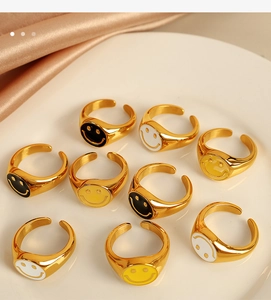 Artistic spread of adjustable 18K gold plated smiley face rings in black white and yellow