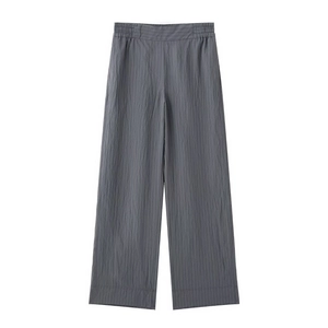 Detail of dark grey wide-leg trousers with vertical pleats and elastic waistband
