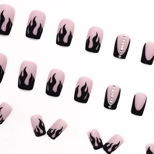 Matte black flame press-on nails with silver rhinestones on a soft pink base