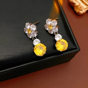 Close-up of silver floral earrings with yellow zircons on black leather display box