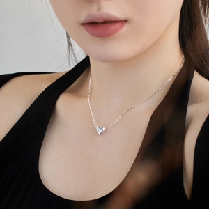 Minimalist S925 sterling silver heart necklace worn by a model to show elegant style