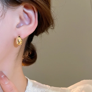 Close-up of elegant 18K gold plated teardrop earring on model showing glossy finish