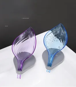 Detail of leaf-shaped soap dishes with drainage design on a white ceramic sink