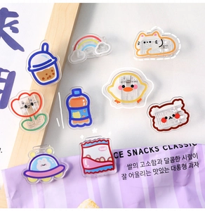 Collection of nine colorful acrylic clips in cute animal and food shapes on white background