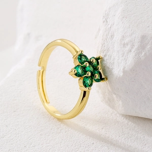 45-degree angle of 18K gold plated flower ring with emerald zircon stones on stone base