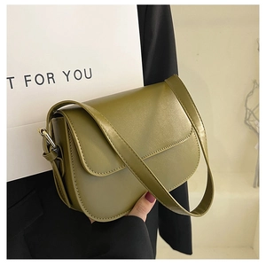 Detail of olive green vintage leather bag with magnetic flap and gold hardware