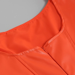 Vue détaillée du col en U et des surpiqûres sur la robe en similicuir orange vif