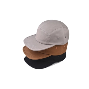 Vista dettagliata di tre cappellini 5-panel in cotone nei colori grigio, marrone e nero