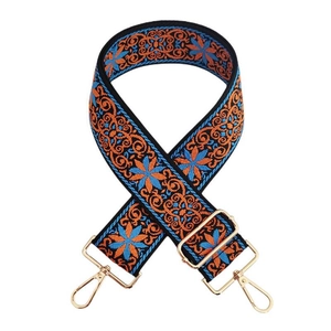 Gros plan d'une bandoulière brodée en jacquard avec motifs bleus et boucles dorées