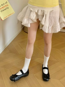 Gros plan de chaussures Mary Jane noires à nœud avec jupe en dentelle blanche