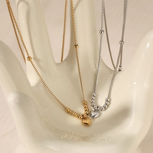 Herzanhänger Halsketten aus Edelstahl in Gold und Silber auf weißem Schmuckständer