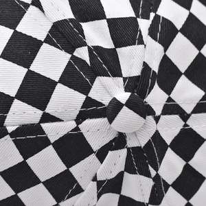 Macro detail of the top button and stitching on a cotton checkerboard baseball cap