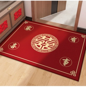 Detail of red wedding rug with gold Xi characters on wooden floor for home entrance