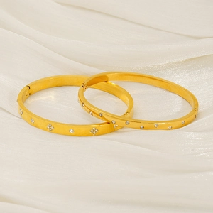 Luxurious 18k gold-plated stainless steel bangles with floral zircon inlay on white fabric