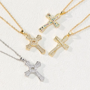 Detail of four cross pendants with white zircons and colorful stones on a textured surface