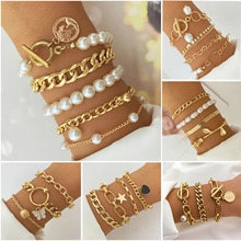 Detail of bohemian gold bracelet set with pearls, butterfly and star charms for women