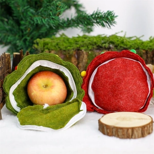 Close-up of red and green felt Christmas gift bags with zipper closure on snow background