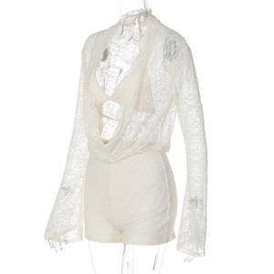 Détail d'un body blanc en dentelle à manches longues avec col en V et motifs floraux