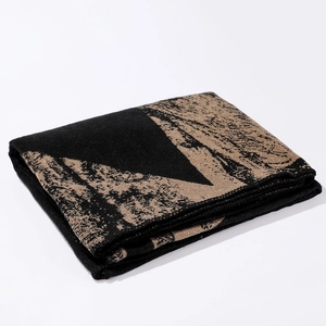 Detail of folded thick shawl with abstract landscape pattern in black and brown