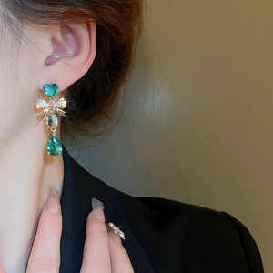 Vue détaillée des boucles d'oreilles émeraude en forme de cœur et goutte avec nœud