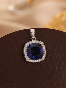 Close-up of square cut blue zircon pendant with halo diamonds on silver setting