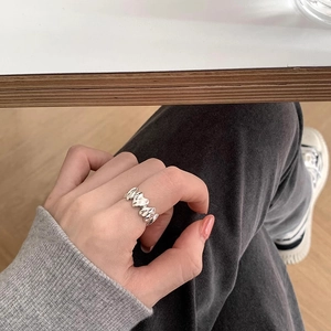 Minimalist silver heart ring with polished faceted surface shown on female hand