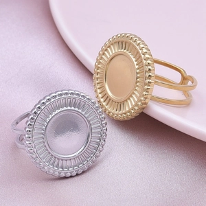 Macro shot of gold and silver sunburst bezel ring bases on pink satin background