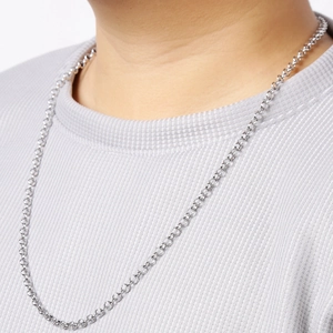 Close-up of a silver stainless steel pearl chain necklace worn on a model's neck