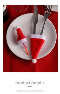 Close-up of mini red flannel Christmas hats used as cutlery holders on a white dinner plate